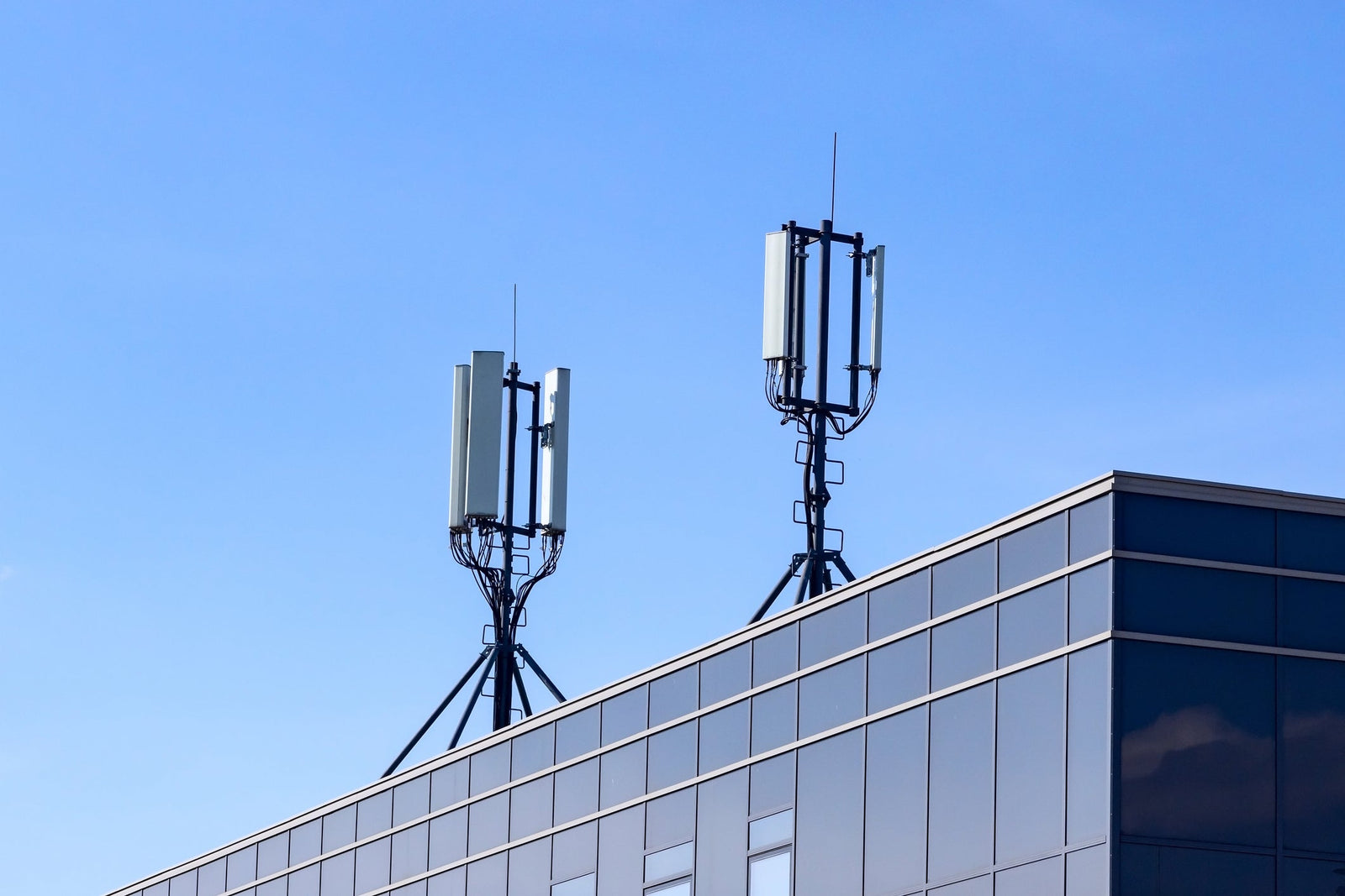Rooftop cellular panel antennas against a blue sky