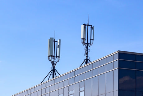 Rooftop cellular panel antennas against a blue sky